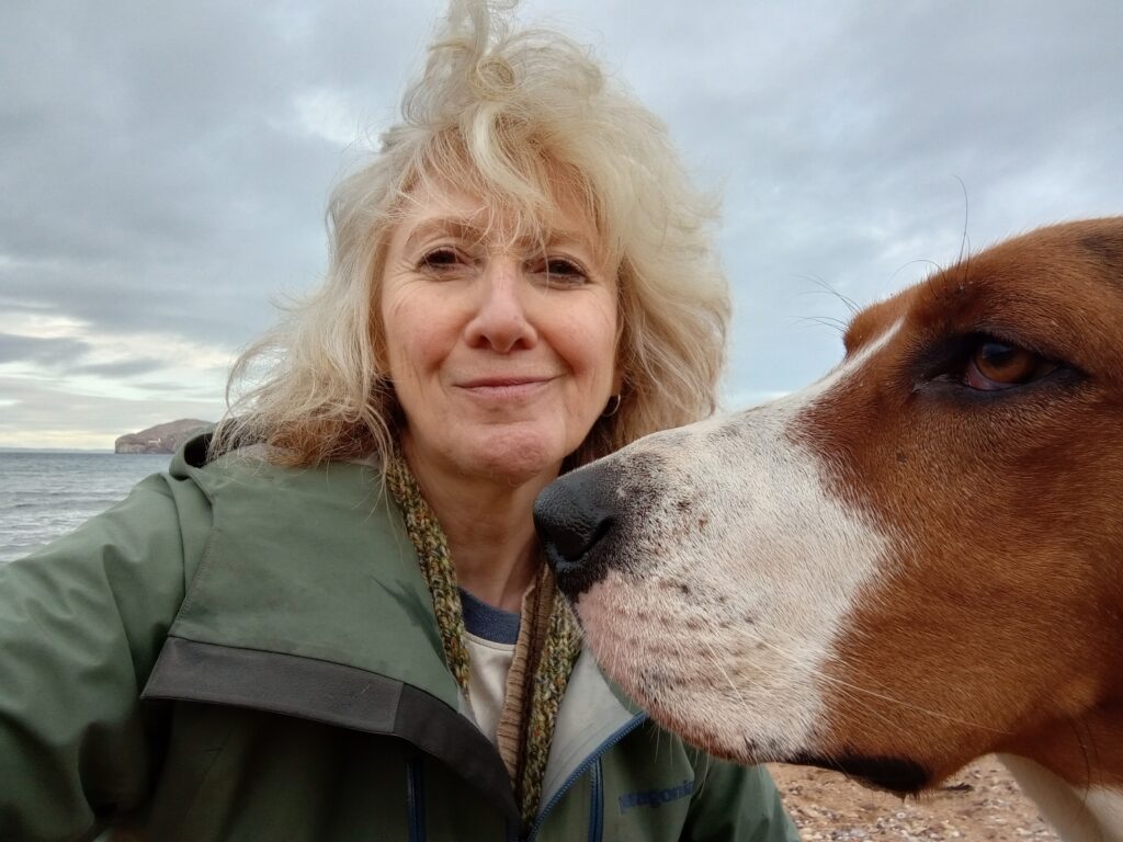 Headshot of Joanne Frame with dogs head in profile